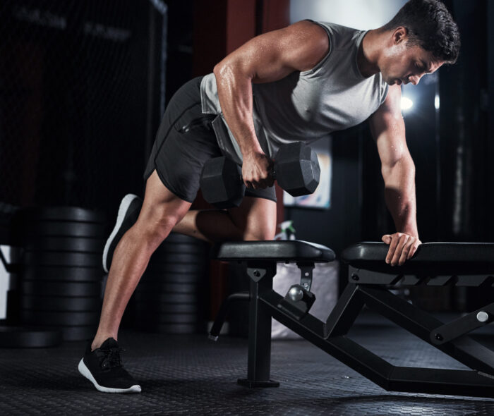 Man, weightlifting and dumbbell as bodybuilder or athlete in sports practice, training and gym. Male person, equipment and routine for challenge, muscle and wellness in workout, fitness and exercise Man, weightlifting and dumbbell as bodybuilder or athlete in sports practice, training and gym. Male person, equipment and routine for challenge, muscle and wellness in workout, fitness and exercise.